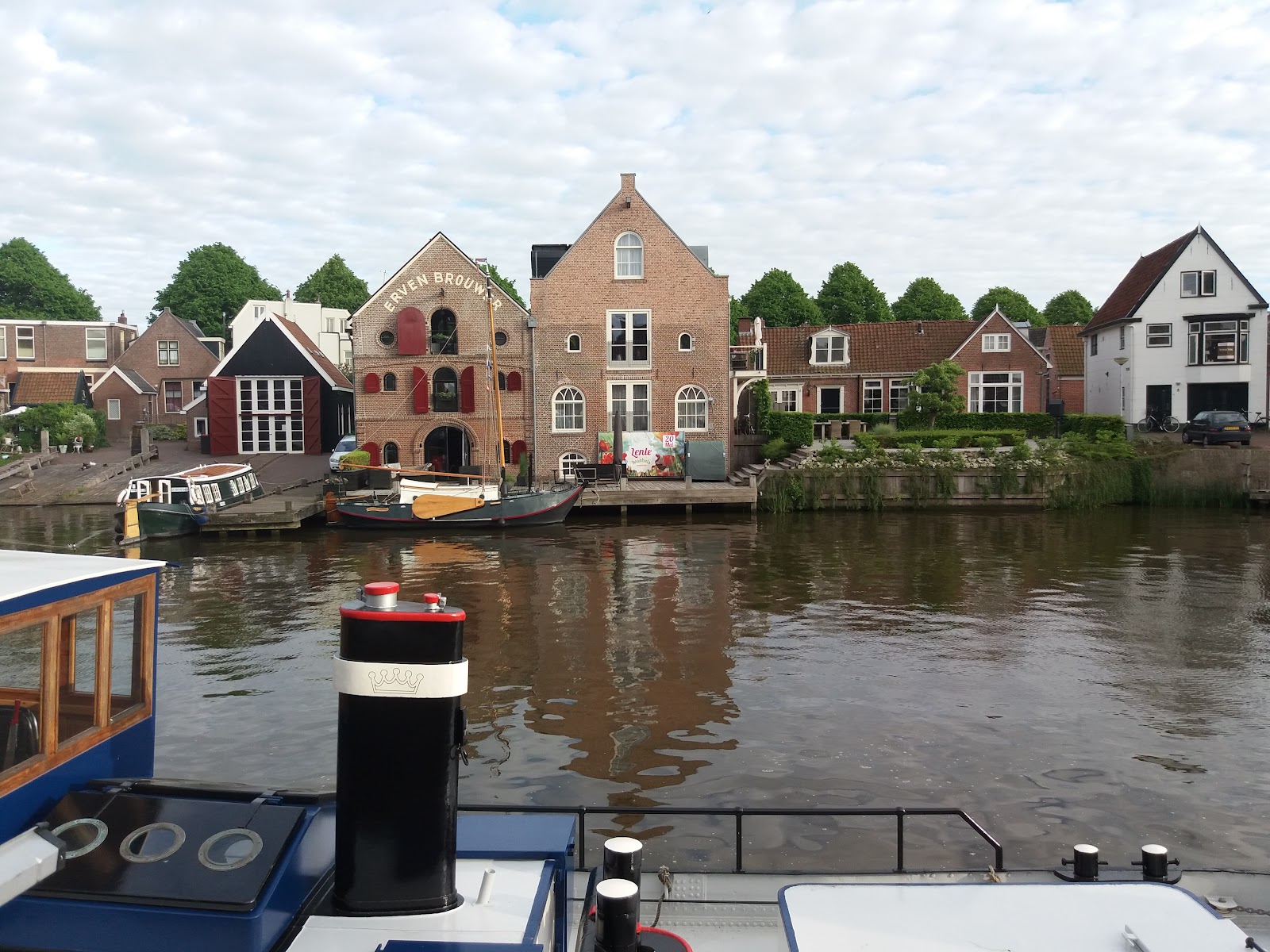 Historische Nederlandse grachtenpanden met aangemeerde boten in Dokkum